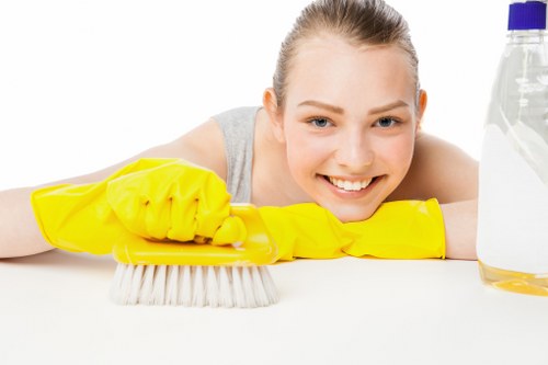 Staff member using protective gloves and cleaning supplies during carpet cleaning